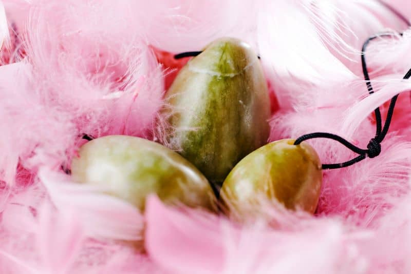Roze veren en jade eitjes voor bekkenbodemoefeningen tegen urineverlies.